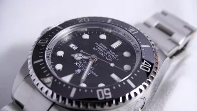 silver-colored Rolex analog watch reading at 1:55