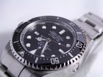 silver-colored Rolex analog watch reading at 1:55