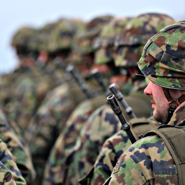 man in green and brown camouflage uniform holding black rifle