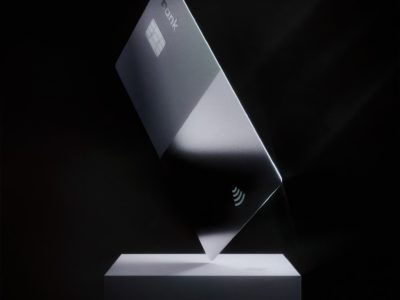 a silver credit card on top of a white stand
